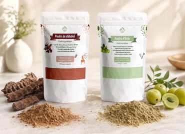 Poudre de Shikakai et Poudre d’Amla de Lotus Bio sur un plan de marbre clair, avec leurs matières premières autour, en lumière naturelle douce, amla et shikakai