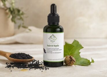 Huile de Nigelle de Lotus Bio sur un plan de marbre clair, avec sa matière première autour, en lumière naturelle douce