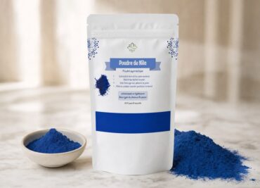 Poudre de Nila de Lotus Bio sur un plan de marbre clair, avec sa matière première autour, en lumière naturelle douce